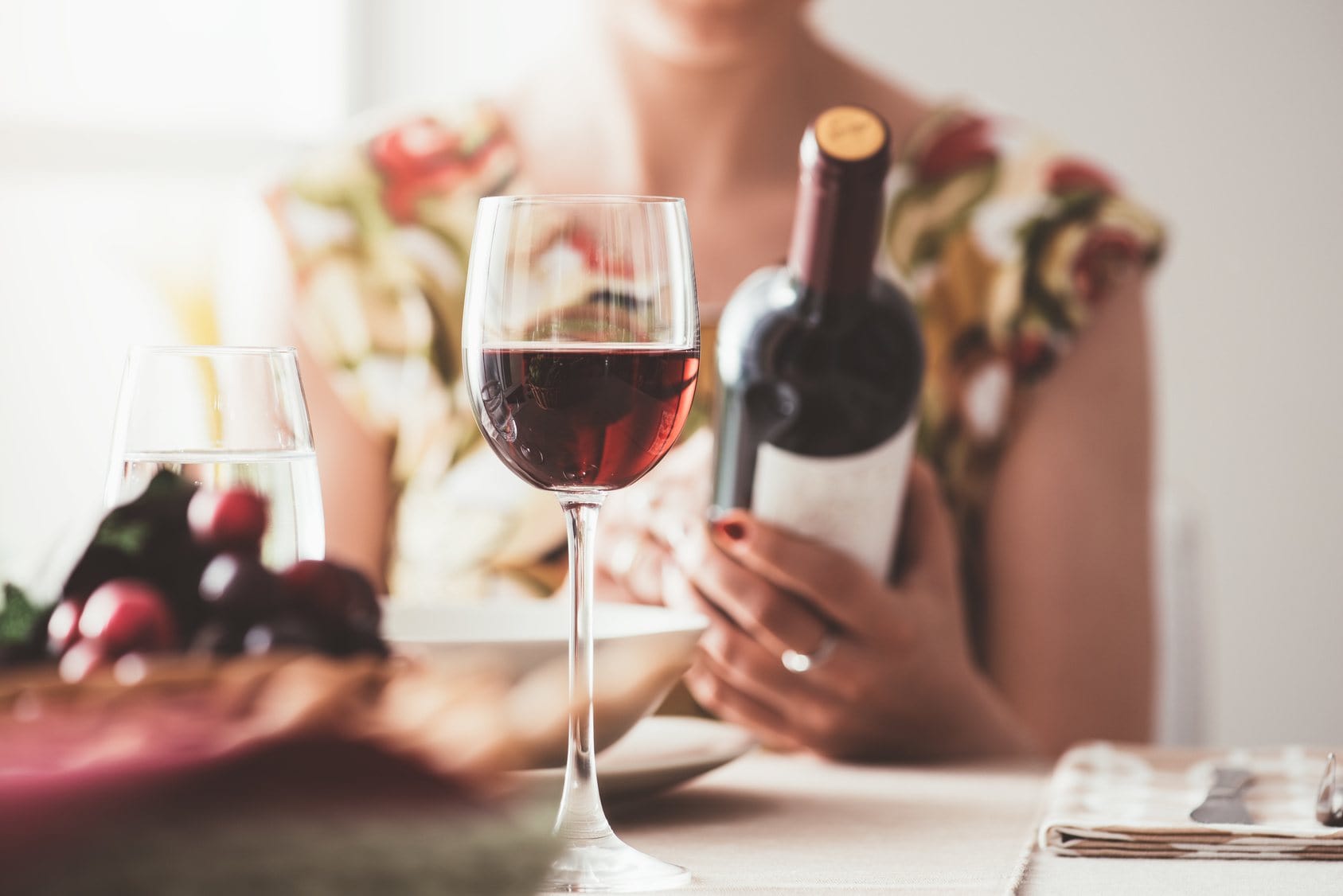 LAdy holding bottle if wine